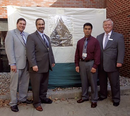 Standing in front of the sukkah in the courtyard at Overlook Medical Center in Summit are, from left, CEO and publisher of TAPinto.net Michael Shapiro, Overlook’s Food Service Manager Michael Attanasio, Medical Imaging Coordinator Bertin Navarro and Overlook Medical Center Administrator Gerry Durney. Not pictured is Rabbi Nathan Zemel, a member of Overlook Medical Center’s department of Pastoral Care and the hospital’s Diversity Committee. (Credit: Barbara Rybolt)