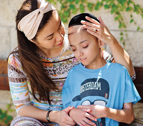 Uriel Wang receives comforting words from his mother, after being driven to Hadassah Ein-Kerem Hospital by an ICSN volunteer.